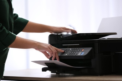 Employee using modern printer in office, closeup Photo of Employee using modern printer in office, closeup
