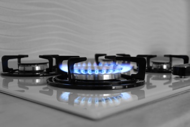 Modern gas cooktop with burning blue flame in kitchen Photo of Modern gas cooktop with burning blue flame in kitchen