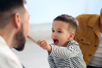 Mother and son visiting pediatrician in hospital. Doctor playing with little boy Photo of Mother and son visiting pediatrician in hospital. Doctor playing with little boy