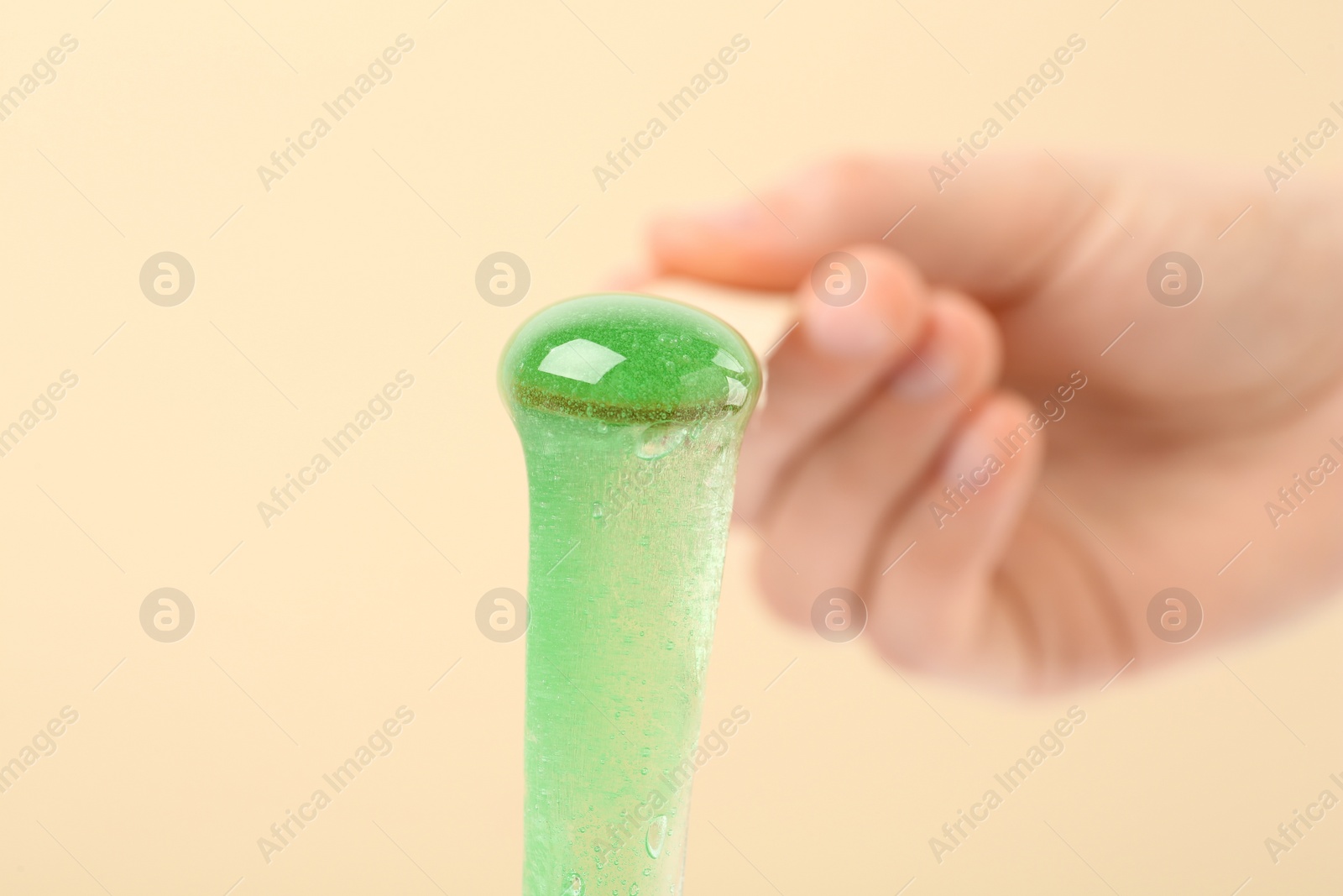 Woman holding spatula with hot depilatory wax on beige background, closeup Photo of Woman holding spatula with hot depilatory wax on beige background, closeup