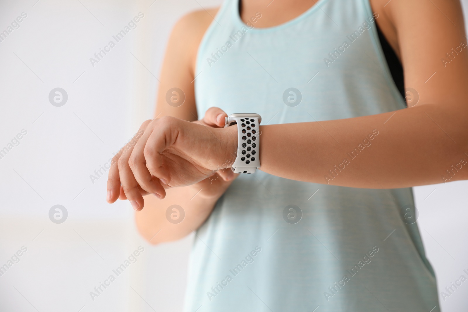 Woman checking fitness tracker indoors, closeup view Photo of Woman checking fitness tracker indoors, closeup view