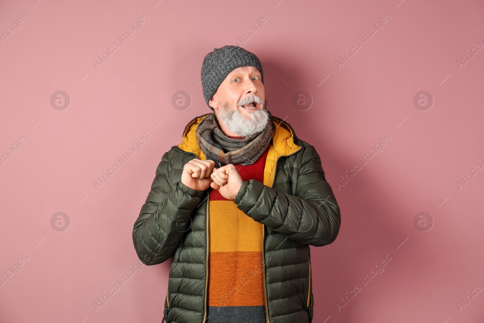 Mature man in warm clothing on color background. Ready for winter vacation Photo of Mature man in warm clothing on color background. Ready for winter vacation