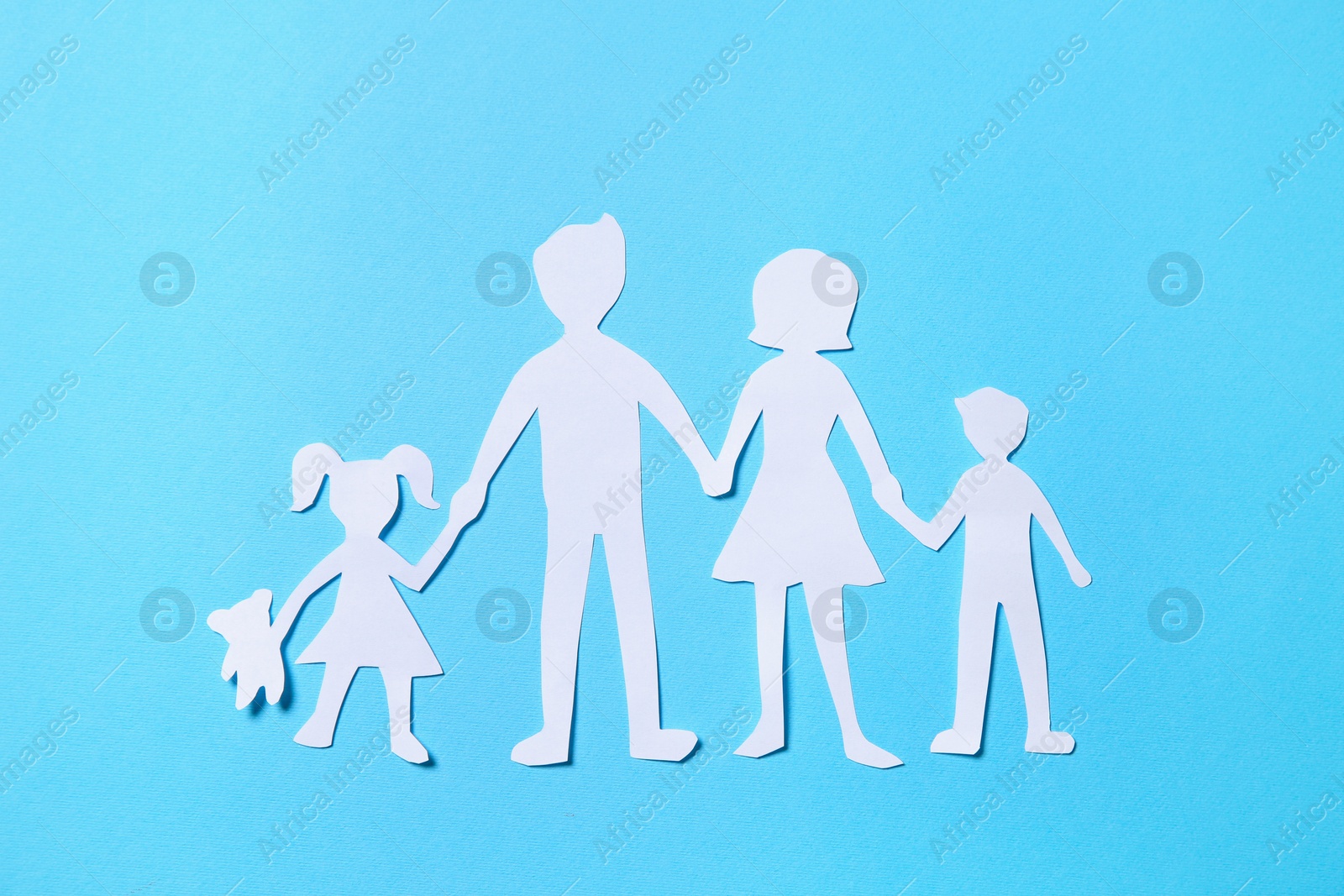 Paper family figures on light blue background, top view Photo of Paper family figures on light blue background, top view