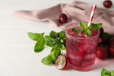 Delicious grape soda water with mint on white table. Refreshing drink Photo of Delicious grape soda water with mint on white table. Refreshing drink