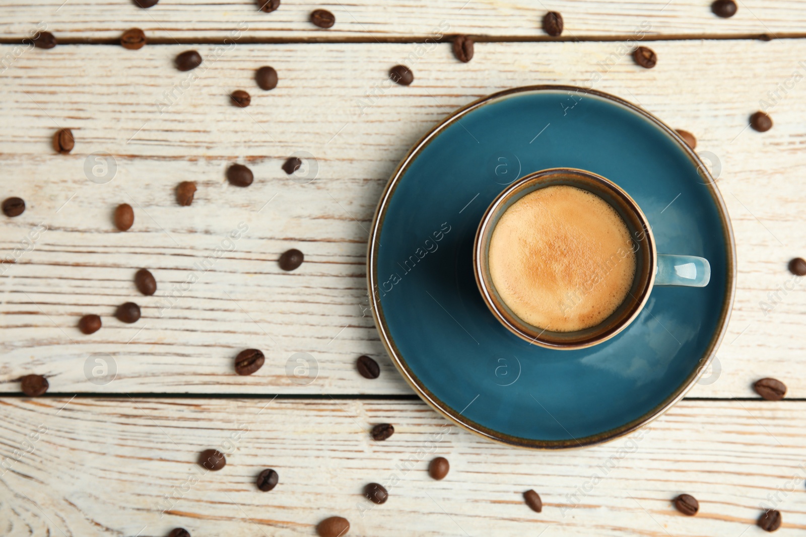 Cup of hot aromatic espresso and roasted beans on white wooden table, flat lay Photo of Cup of hot aromatic espresso and roasted beans on white wooden table, flat lay