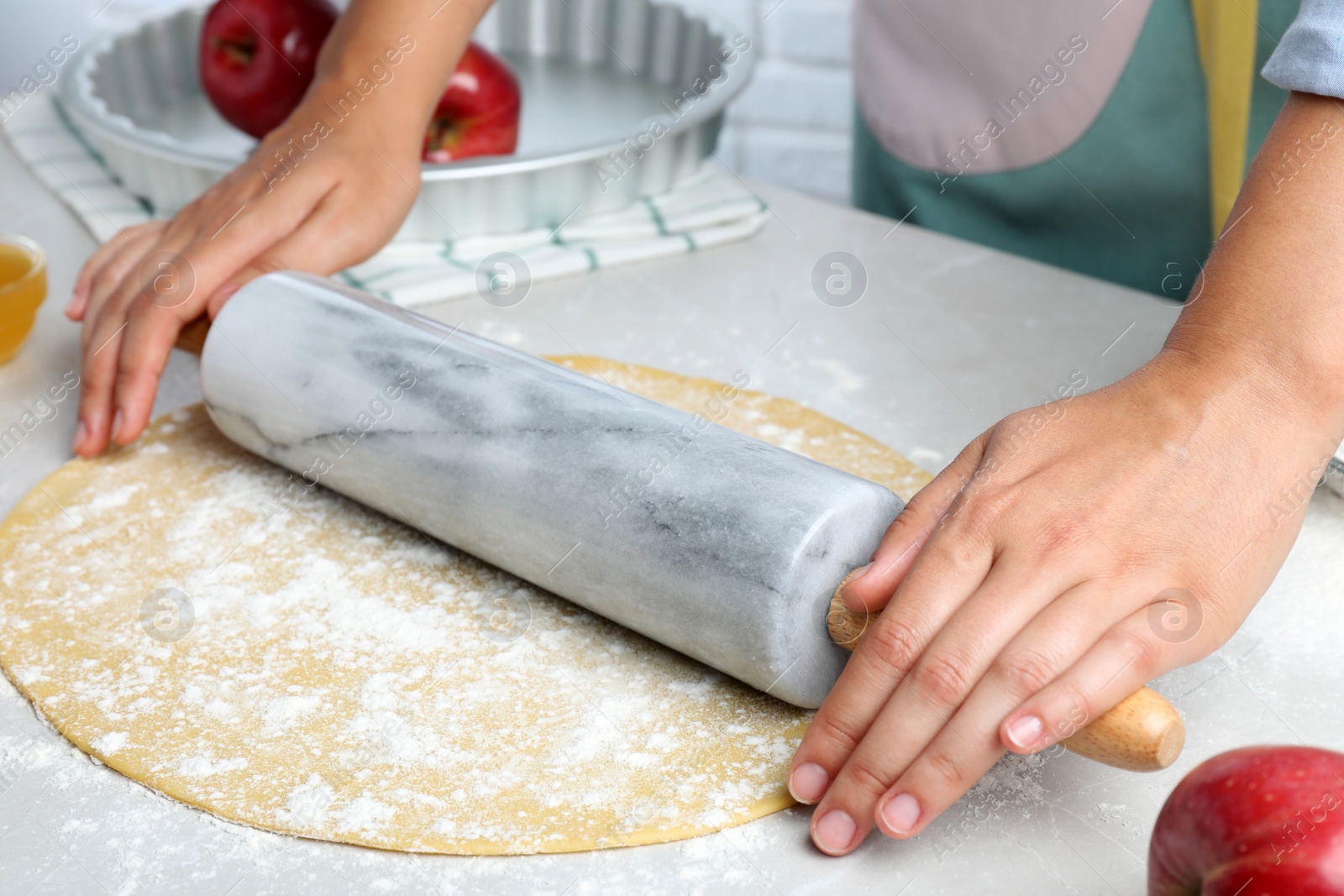 Woman rolling dough for apple pie at light grey table, closeup Photo of Woman rolling dough for apple pie at light grey table, closeup