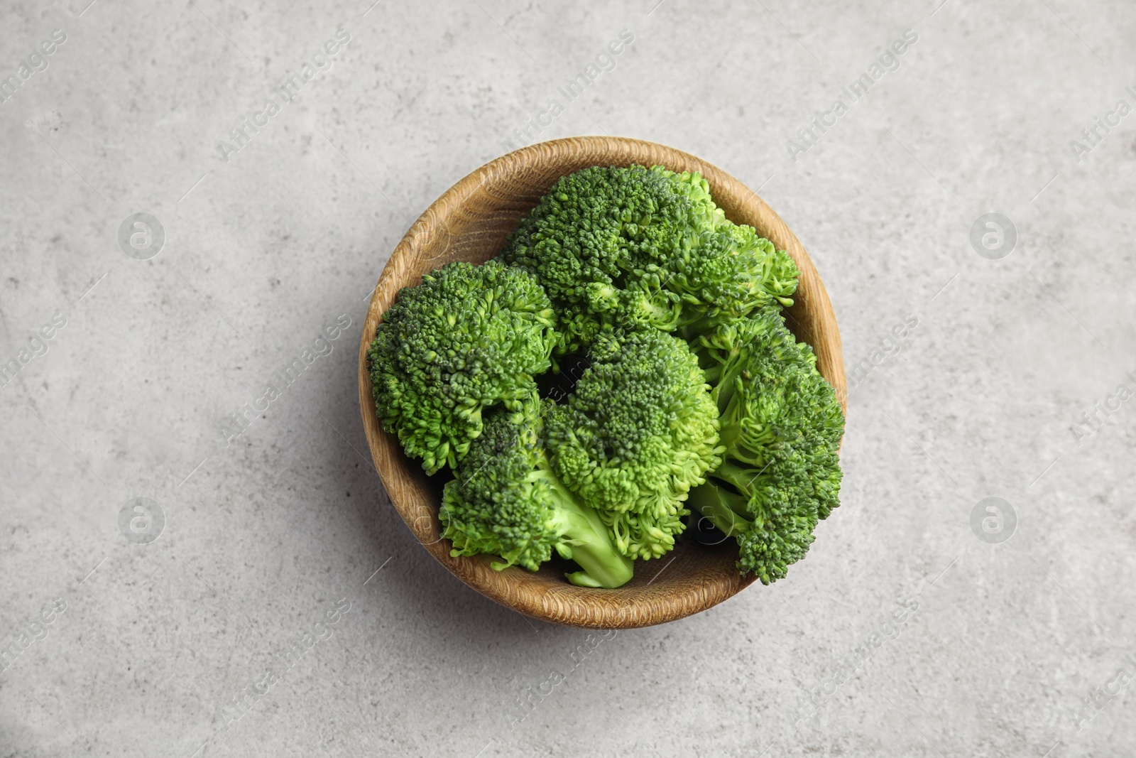 Fresh green broccoli in bowl on light table, top view Photo of Fresh green broccoli in bowl on light table, top view