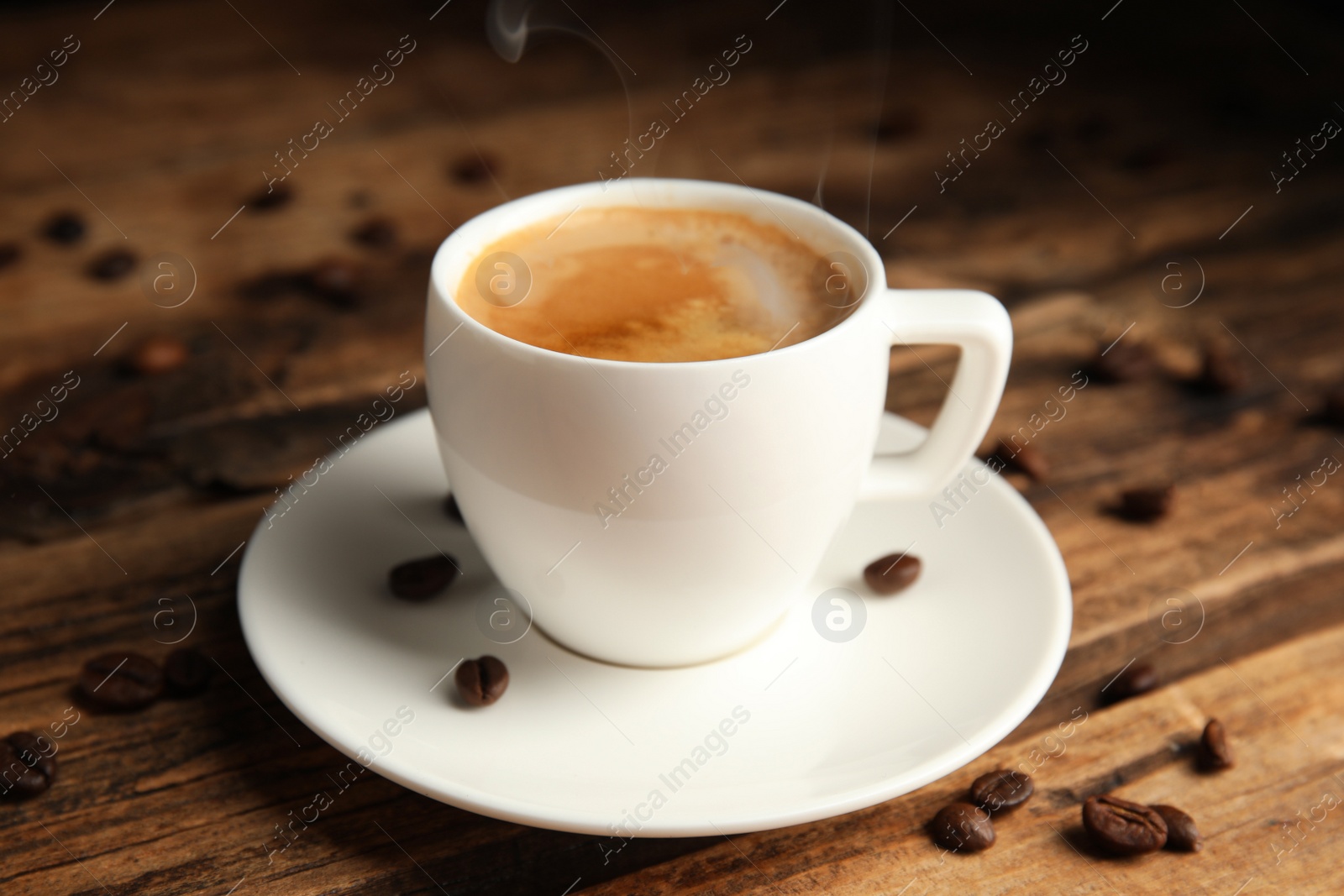 Cup of tasty coffee and beans on wooden table Photo of Cup of tasty coffee and beans on wooden table