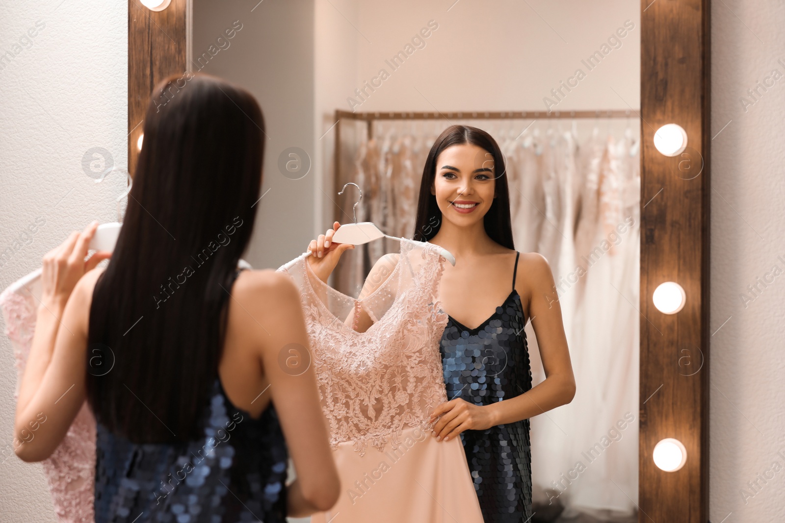 Woman choosing dress in rental clothing salon Photo of Woman choosing dress in rental clothing salon