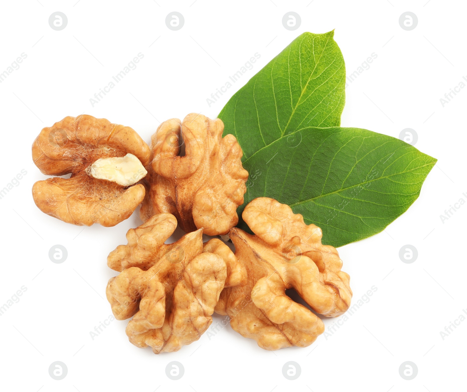 Pile of peeled walnuts and leaves on white background, top view Photo of Pile of peeled walnuts and leaves on white background, top view