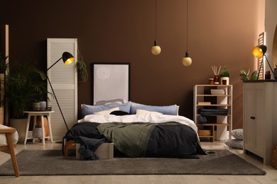 Photo of Stylish room interior with large bed near brown wall