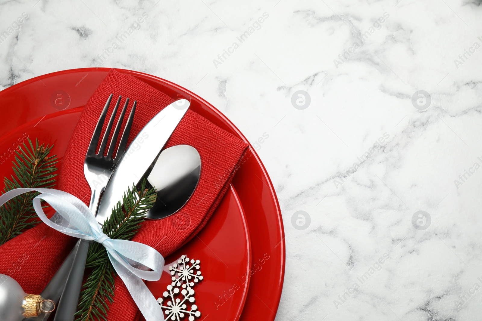 Festive table setting with beautiful dishware and Christmas decor on white marble background, top view. Space for text Photo of Festive table setting with beautiful dishware and Christmas decor on white marble background, top view. Space for text