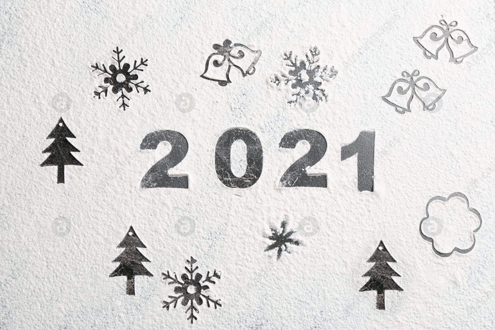 Photo of Different Christmas drawings and number 2021 made of flour on grey table, top view