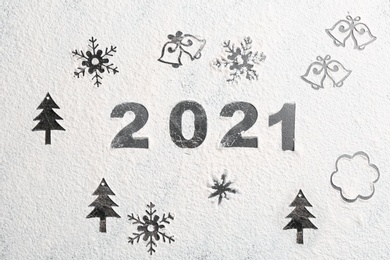 Photo of Different Christmas drawings and number 2021 made of flour on grey table, top view
