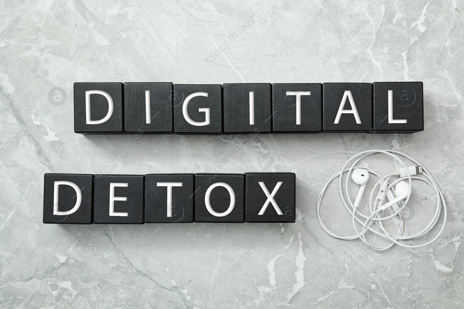 Black cubes with words DIGITAL DETOX and earphones on light grey marble background, flat lay Photo of Black cubes with words DIGITAL DETOX and earphones on light grey marble background, flat lay
