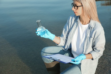 Scientist with clipboard and sample taken from river Photo of Scientist with clipboard and sample taken from river