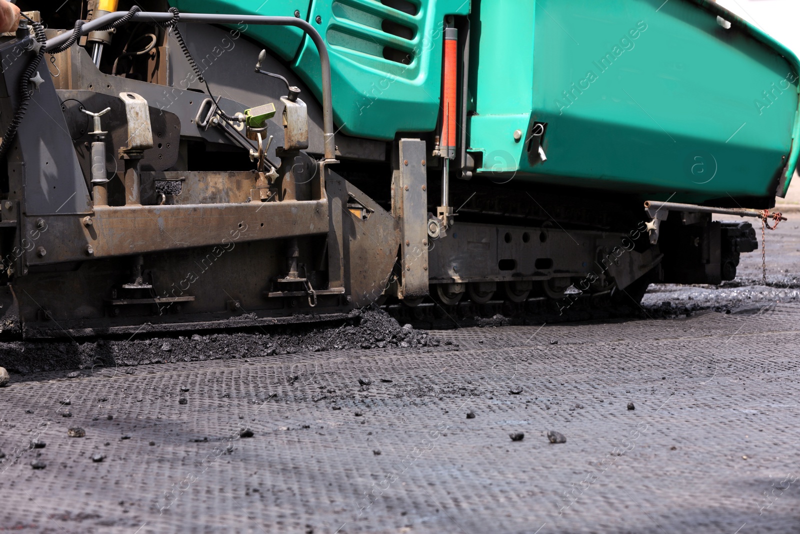 Asphalt paver working on street, closeup. Road repair Photo of Asphalt paver working on street, closeup. Road repair