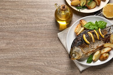 Tasty homemade roasted crucian carp served on wooden table, flat lay and space for text. River fish Photo of Tasty homemade roasted crucian carp served on wooden table, flat lay and space for text. River fish