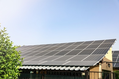House with installed solar panels on roof. Alternative energy source Photo of House with installed solar panels on roof. Alternative energy source