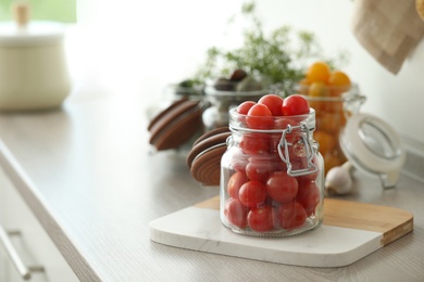 Pickling jar with fresh tomatoes on counter in kitchen. Space for text Photo of Pickling jar with fresh tomatoes on counter in kitchen. Space for text