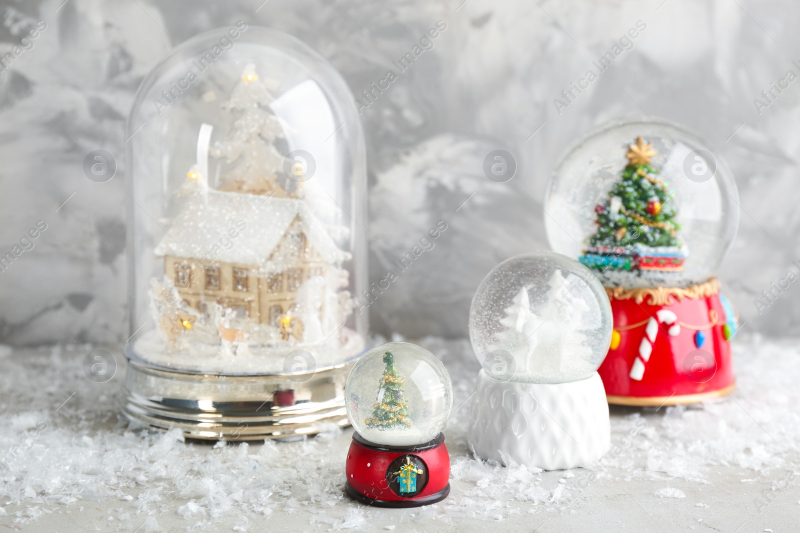 Set of different beautiful snow globes on table Photo of Set of different beautiful snow globes on table