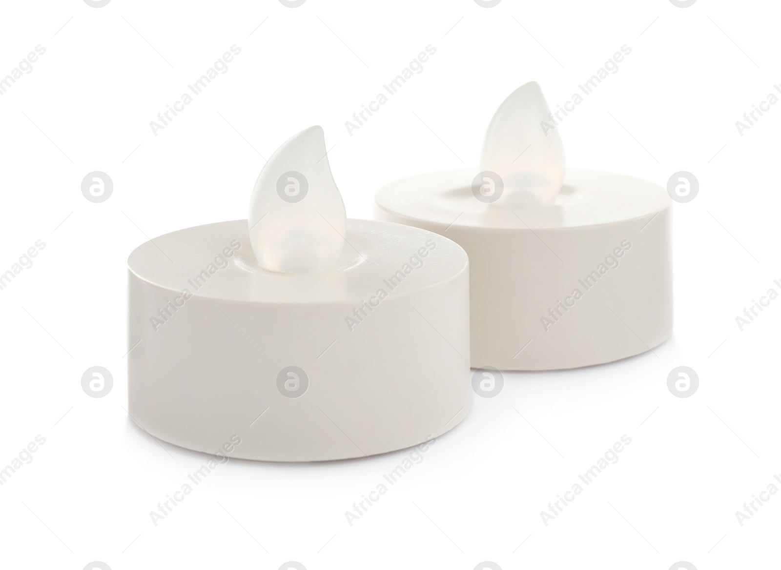 Decorative flameless LED candles on white background Photo of Decorative flameless LED candles on white background