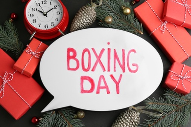 Flat lay composition with Boxing Day sign and Christmas gifts on black table Photo of Flat lay composition with Boxing Day sign and Christmas gifts on black table