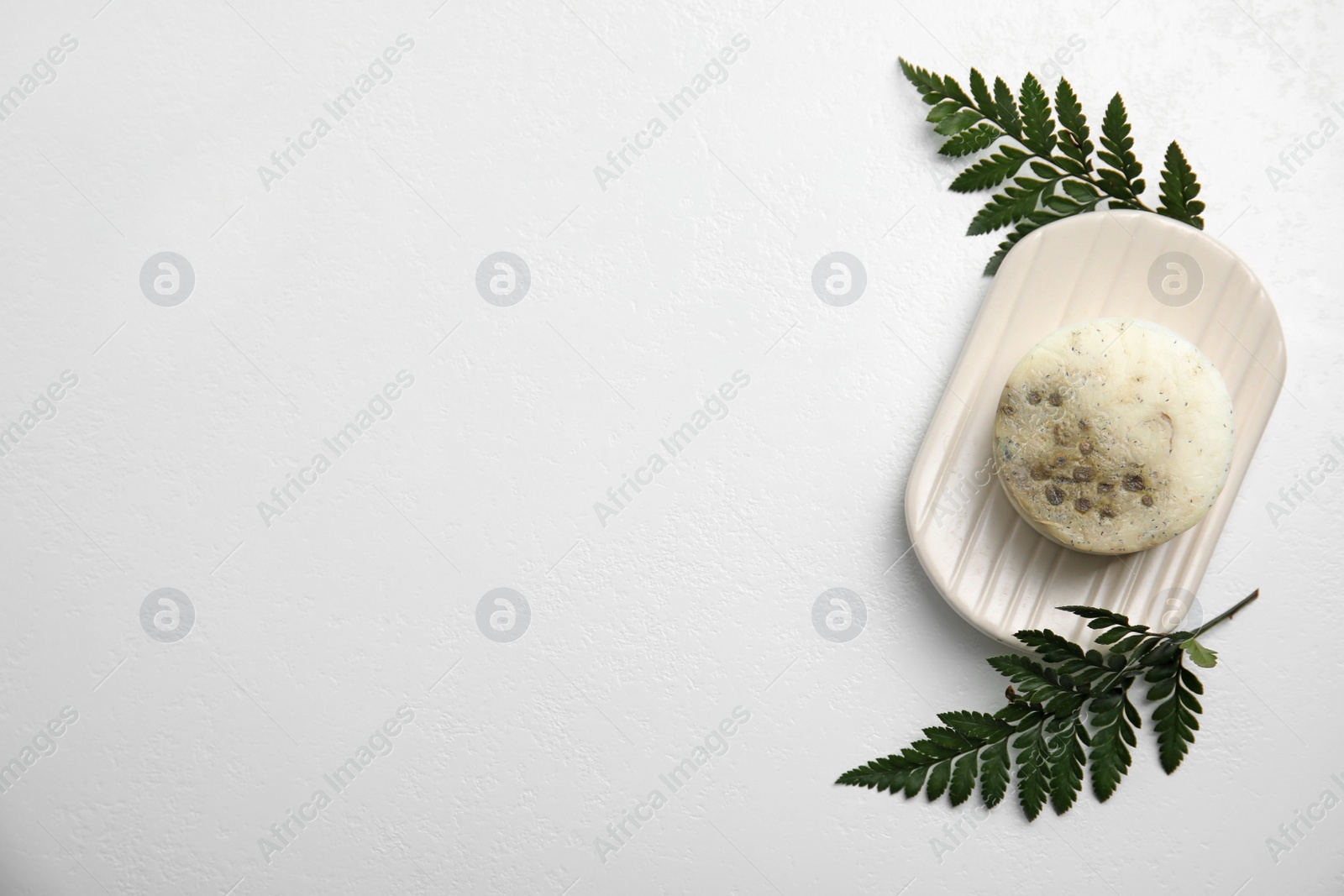 Top view of soap bar with dish and green leaves on white background, space for text. Eco friendly personal care product Photo of Top view of soap bar with dish and green leaves on white background, space for text. Eco friendly personal care product