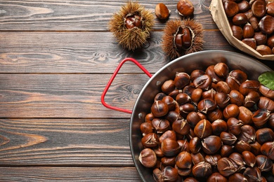 Delicious roasted edible chestnuts on brown wooden table, flat lay. Space for text Photo of Delicious roasted edible chestnuts on brown wooden table, flat lay. Space for text