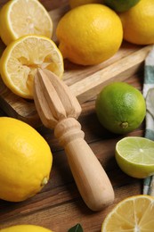 Squeezer with lemons on wooden table, closeup Photo of Squeezer with lemons on wooden table, closeup