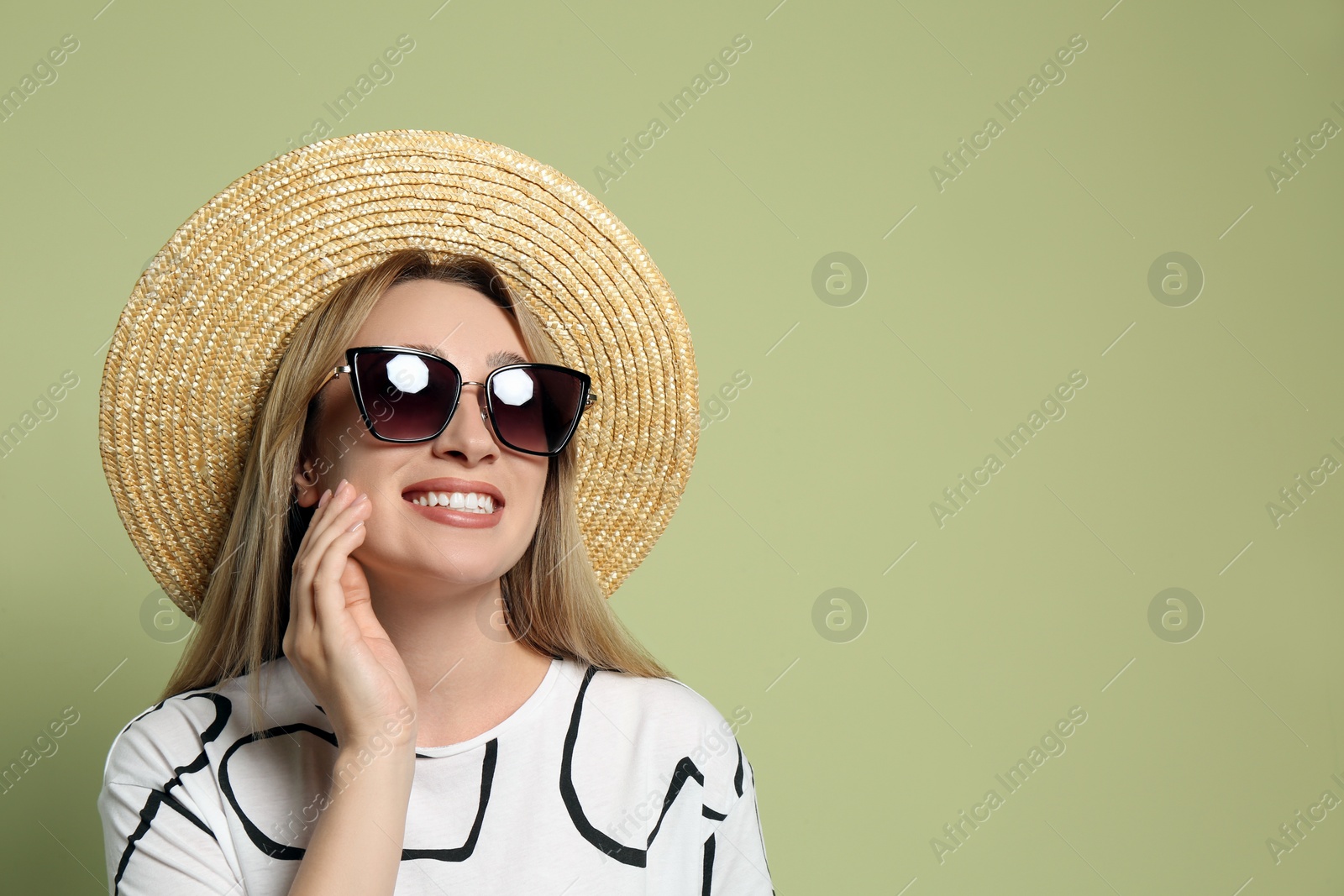 Beautiful young woman wearing straw hat and sunglasses on light green background, space for text. Stylish headdress Photo of Beautiful young woman wearing straw hat and sunglasses on light green background, space for text. Stylish headdress