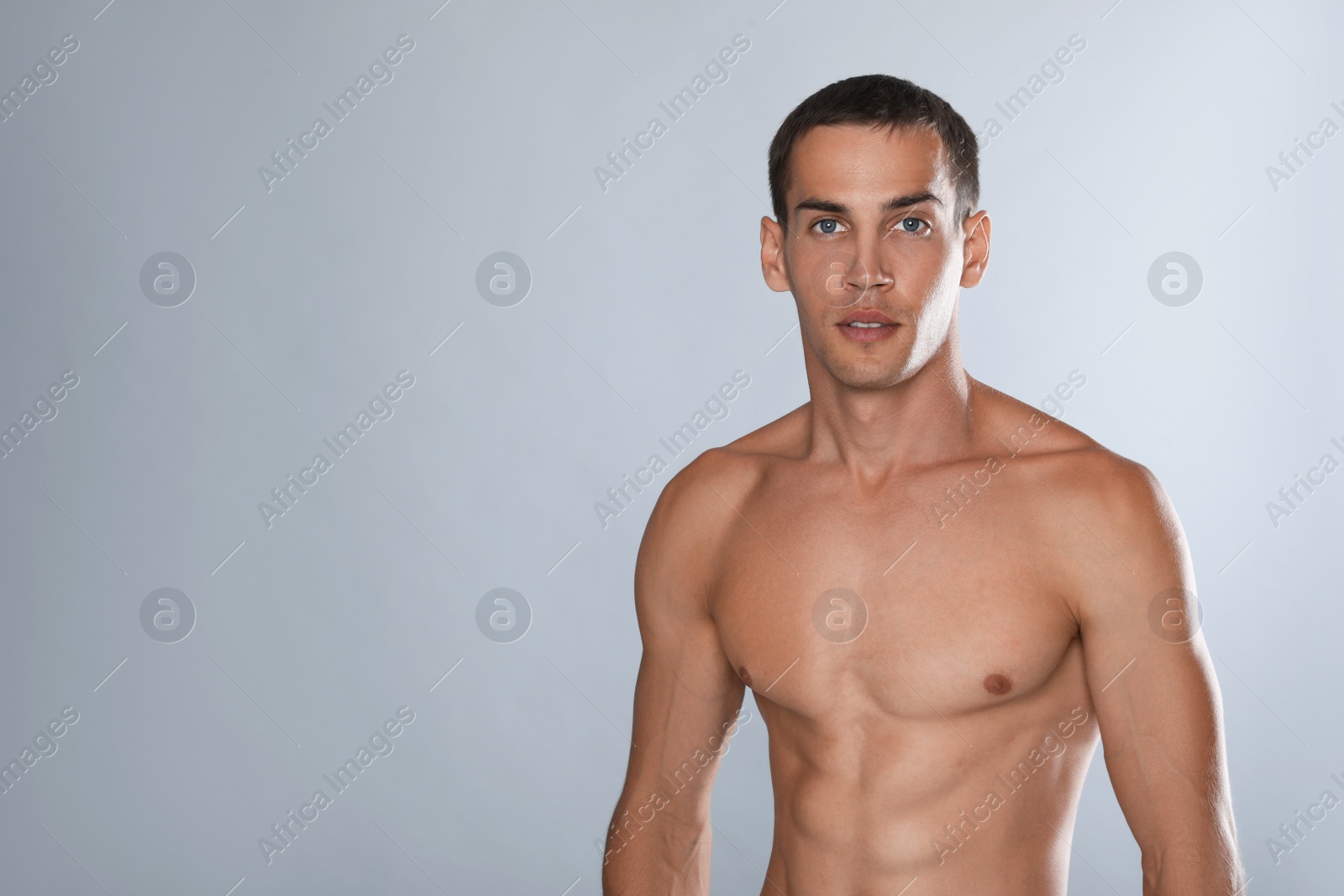 Handsome shirtless man with slim body on grey background. Space for text Photo of Handsome shirtless man with slim body on grey background. Space for text