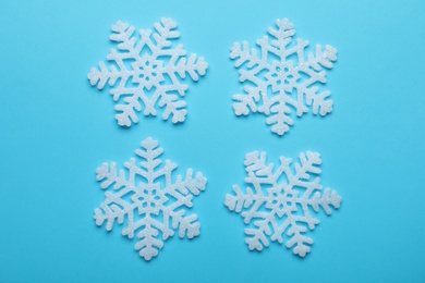 Beautiful decorative snowflakes on light blue background, flat lay Photo of Beautiful decorative snowflakes on light blue background, flat lay