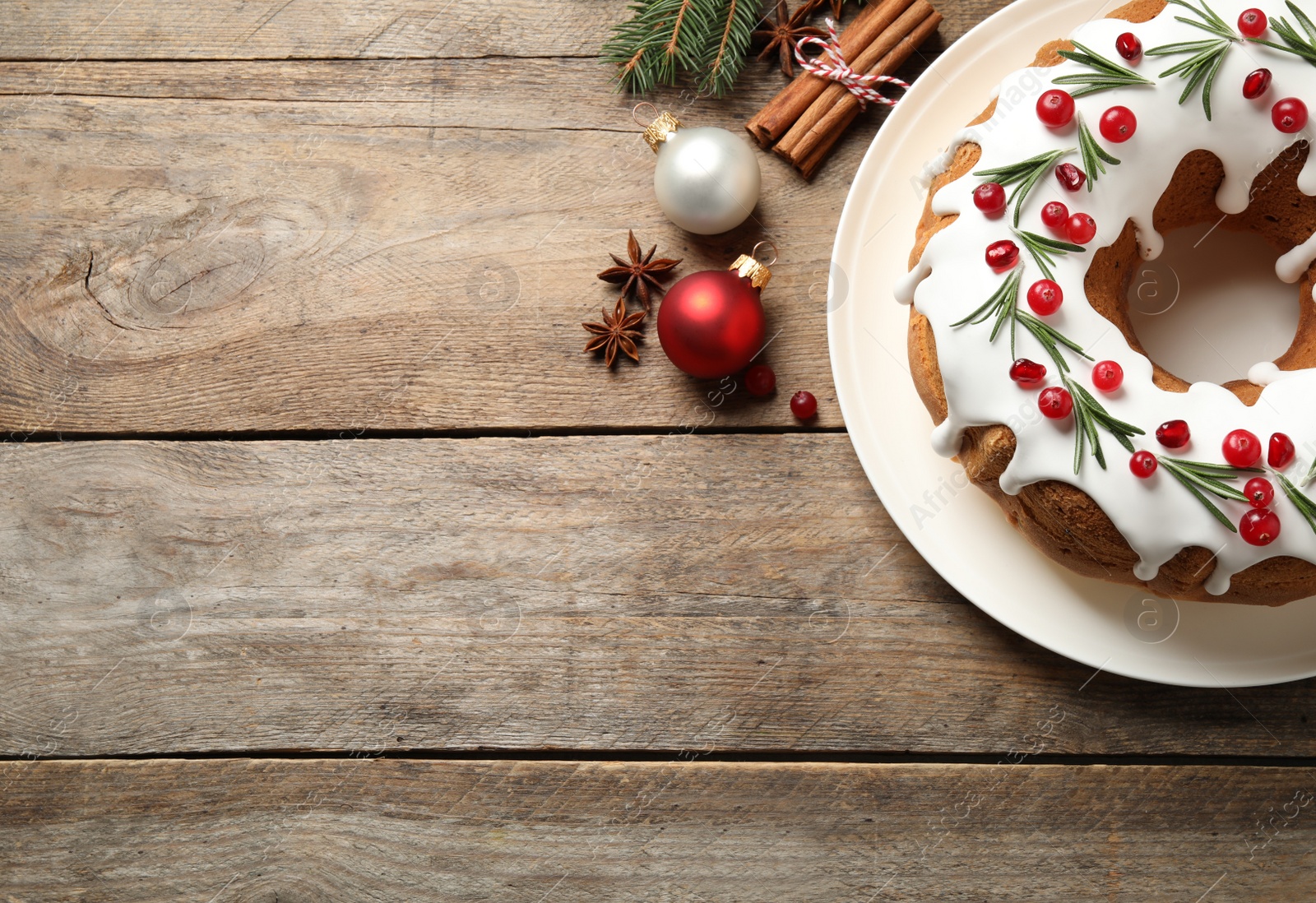 Photo of Flat lay composition with traditional Christmas cake and decorations on wooden table, space for text