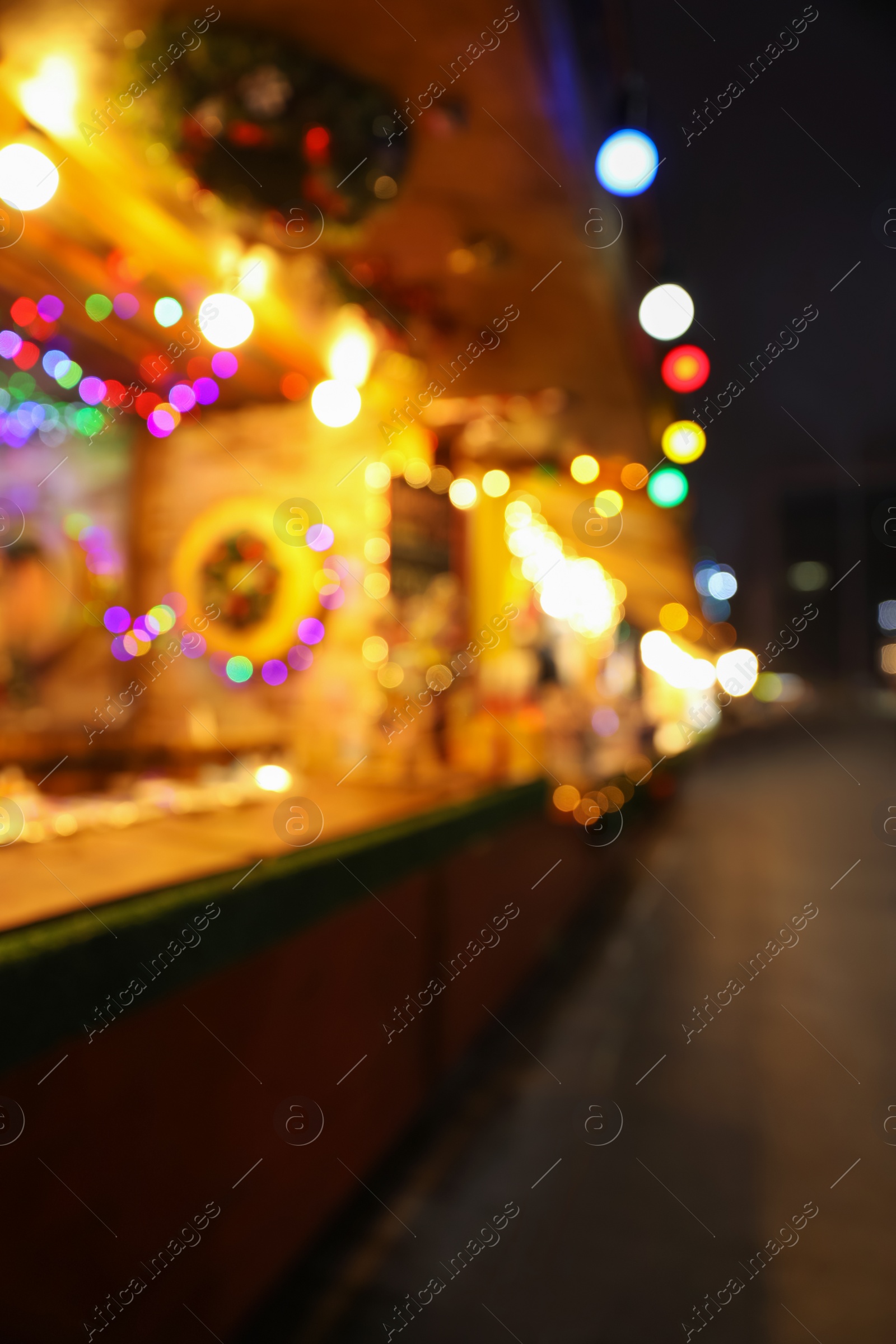 Blurred view of Christmas fair stalls outdoors at night Photo of Blurred view of Christmas fair stalls outdoors at night