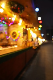 Blurred view of Christmas fair stalls outdoors at night Photo of Blurred view of Christmas fair stalls outdoors at night