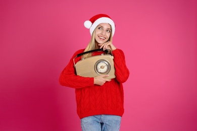 Happy woman with vintage radio on pink background. Christmas music Photo of Happy woman with vintage radio on pink background. Christmas music