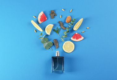Flat lay composition with bottle of perfume on blue background Photo of Flat lay composition with bottle of perfume on blue background
