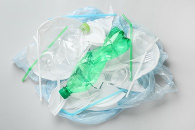 Pile of different plastic items on white background, flat lay Photo of Pile of different plastic items on white background, flat lay