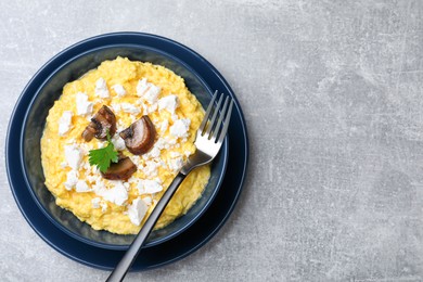 Traditional Ukrainian banosh served with brynza and mushrooms in bowl on grey table, top view. Space for text Photo of Traditional Ukrainian banosh served with brynza and mushrooms in bowl on grey table, top view. Space for text