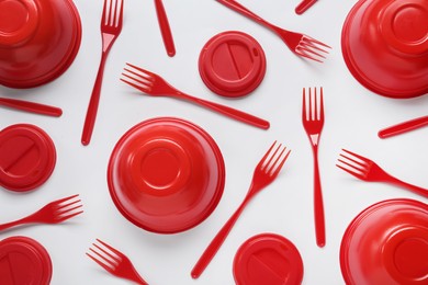 Plastic dishware on white background, flat lay Photo of Plastic dishware on white background, flat lay