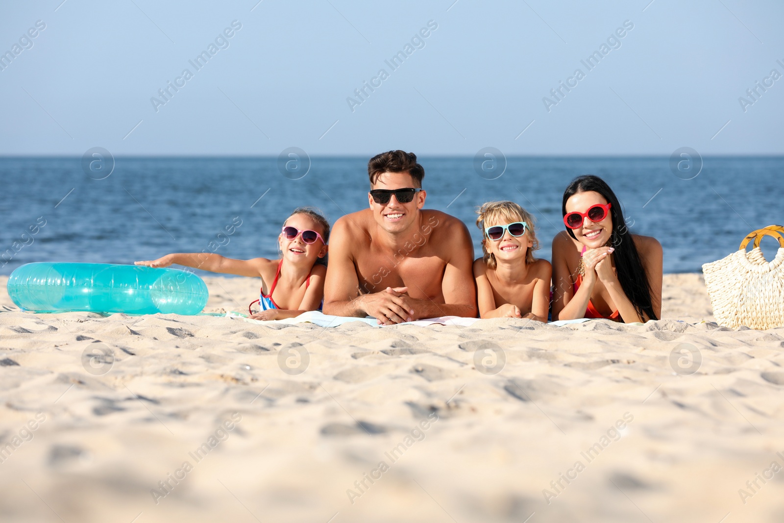Photo of Happy family on sandy beach near sea. Summer holidays