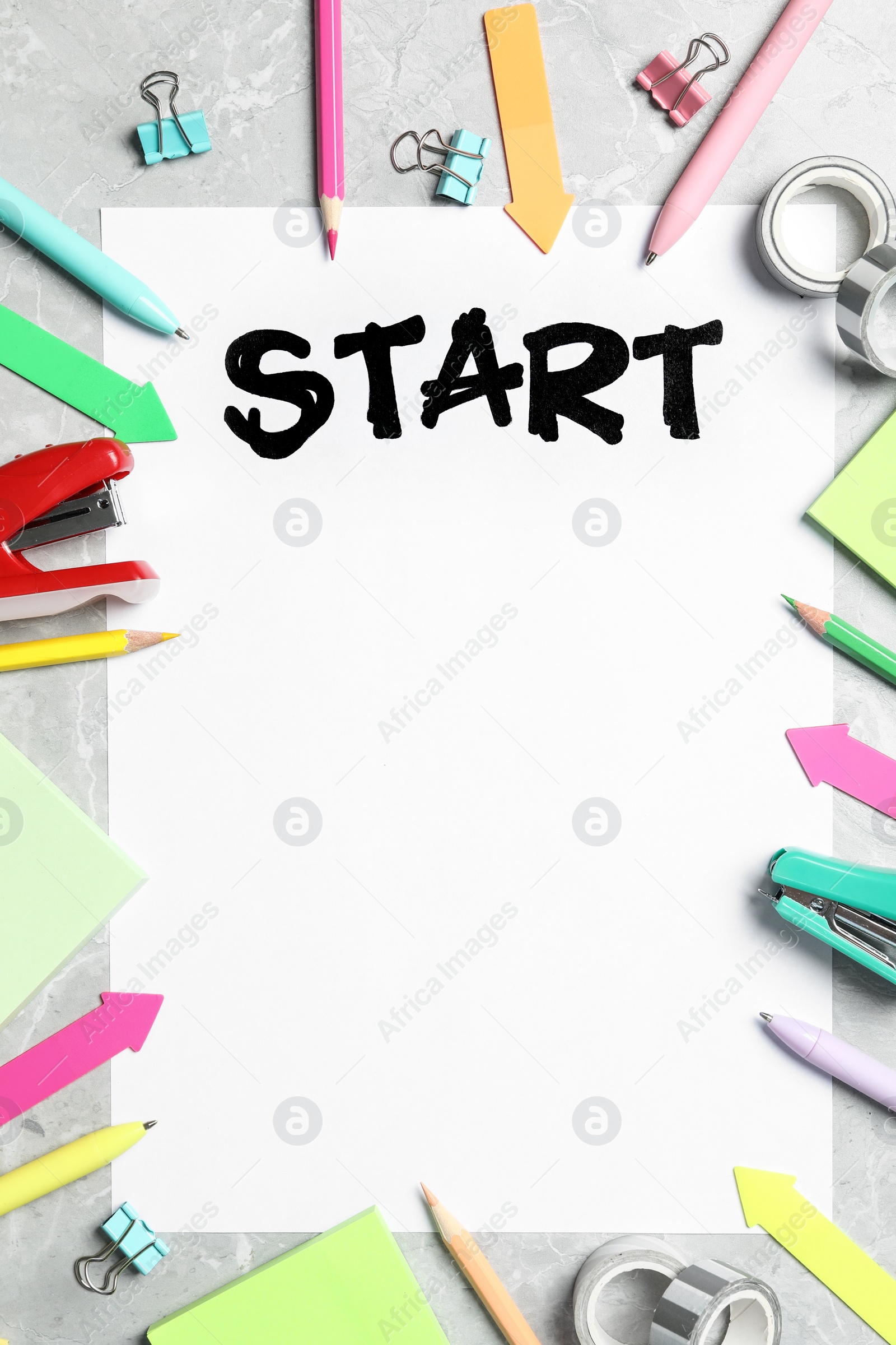 Sheet of paper with word Start and stationery on grey table, flat lay. Space for text Photo of Sheet of paper with word Start and stationery on grey table, flat lay. Space for text