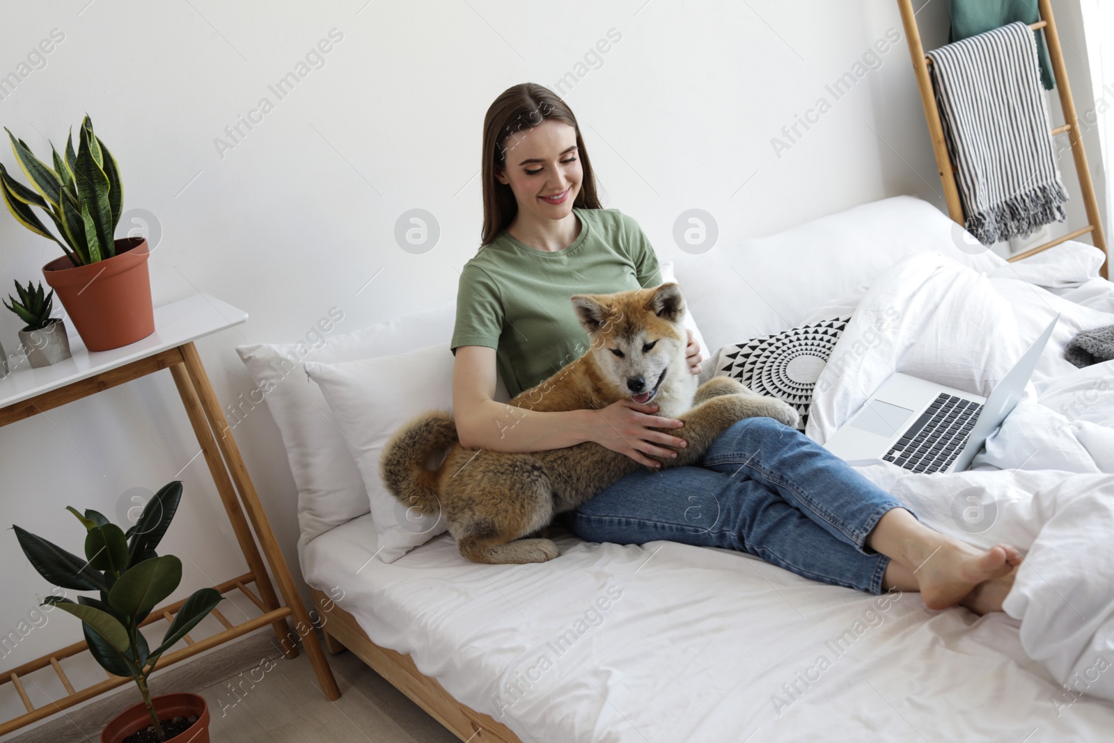 Happy woman with her cute Akita Inu puppy at home Image of Happy woman with her cute Akita Inu puppy at home