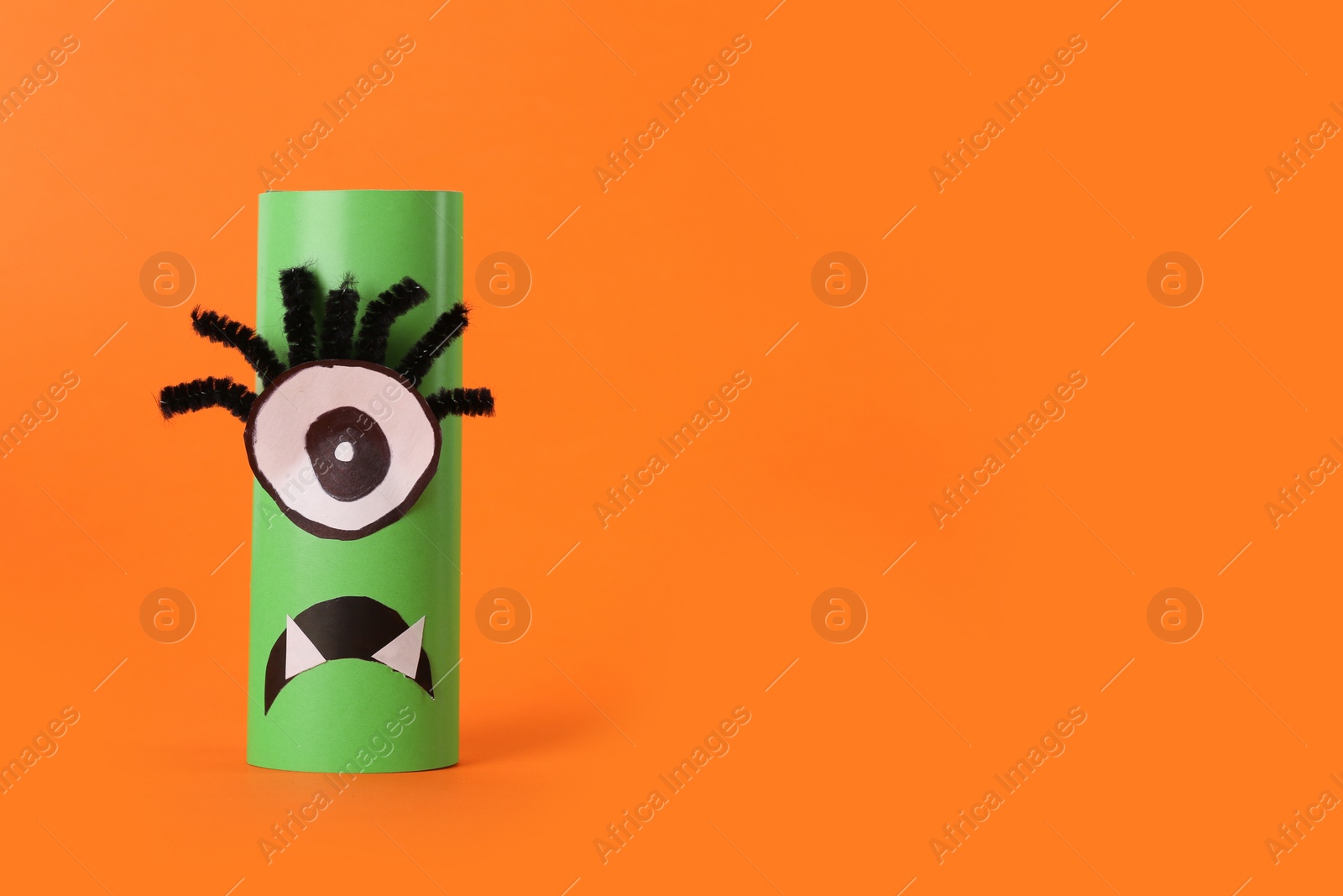 Funny green monster on orange background, space for text. Halloween decoration Photo of Funny green monster on orange background, space for text. Halloween decoration