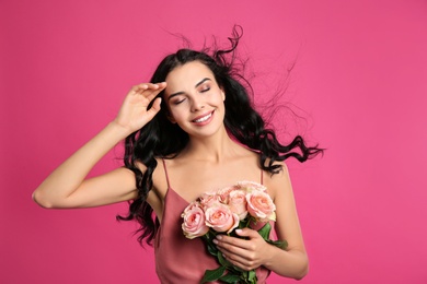 Portrait of smiling woman with beautiful bouquet on pink background Photo of Portrait of smiling woman with beautiful bouquet on pink background