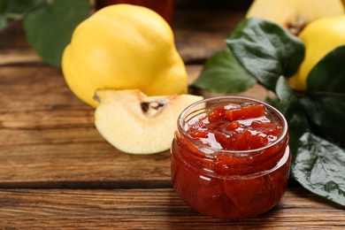 Delicious quince jam and fruit on wooden table, closeup Photo of Delicious quince jam and fruit on wooden table, closeup