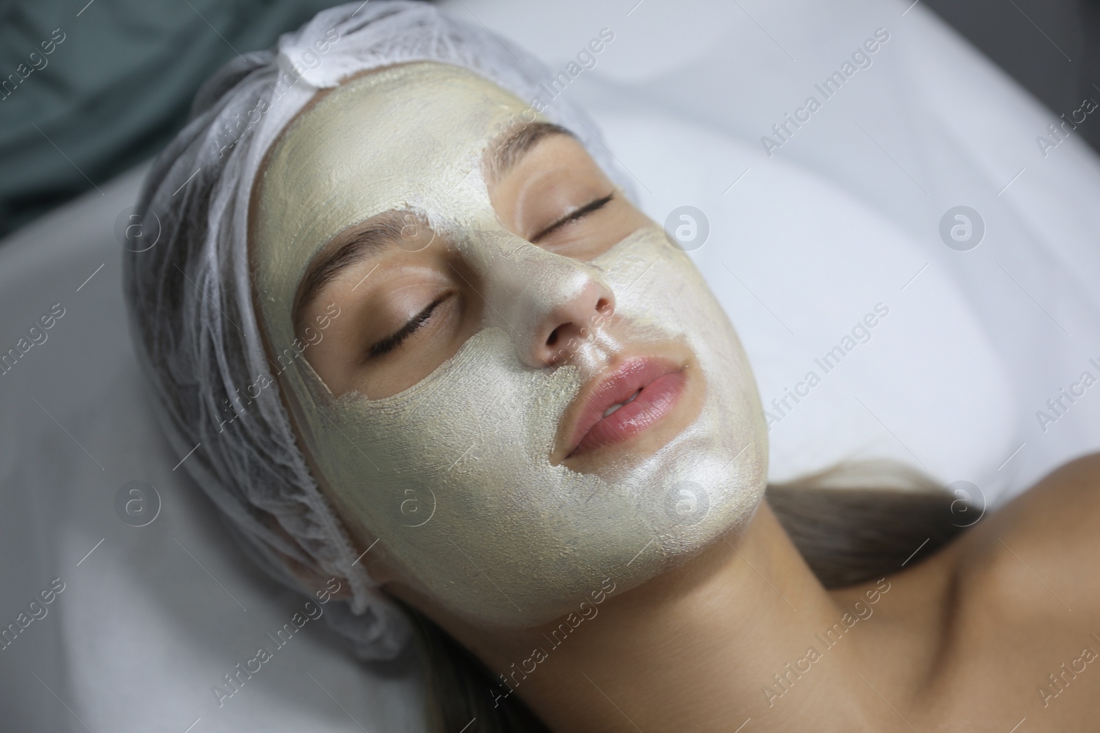 Beautiful woman with mask on her face in spa salon Photo of Beautiful woman with mask on her face in spa salon