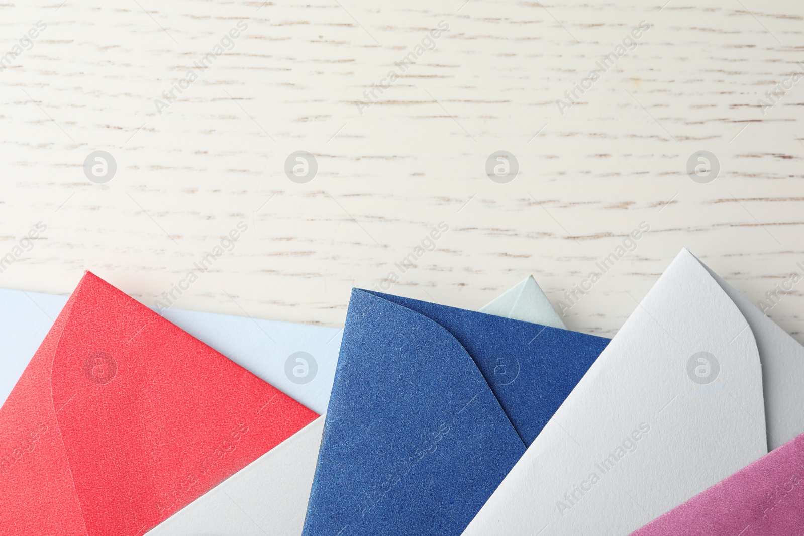 Colorful paper envelopes on white wooden background, flat lay. Space for text Photo of Colorful paper envelopes on white wooden background, flat lay. Space for text