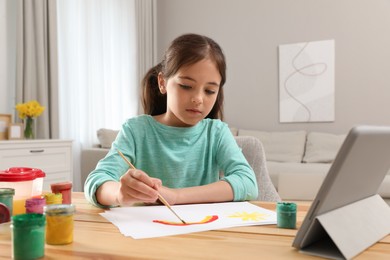 Little girl drawing on paper with paints at online lesson indoors. Distance learning Photo of Little girl drawing on paper with paints at online lesson indoors. Distance learning